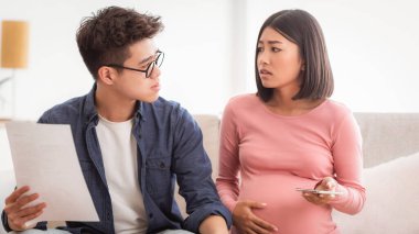 İflas. Masraflarını ve faturalarını hesaplayan ve evdeki koltukta oturan borçlarını ödeyemeyen Asyalı bir çift ekonomik kriz yaşıyor. Mali sorunlar, Coronacrisis kavramı