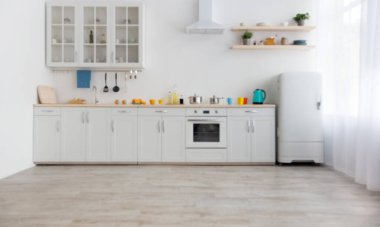 Parlak aksesuarlar ve modern mutfak tasarımı. Mutfak eşyaları, renkli bardaklar ve çaydanlık dolu beyaz mobilyalar çanak çömlek ve bitkilerle dolu raflar, yemek odasındaki buzdolabı, boş alan.