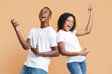 Neşeli siyah erkek ve kadın, sarı arka planda fotokopi odasıyla dans edip şarkı söylüyorlar. Kaygısız Afrikalı Amerikalı çift birlikte eğleniyor, müzik dinliyor, hareket ediyor ve çığlık atıyorlar.