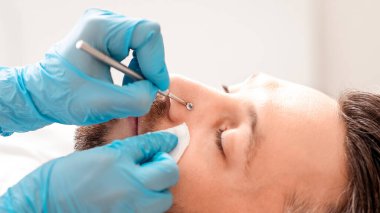 Güzellik salonunda, fotokopi salonunda yüz temizleme ameliyatı olan orta yaşlı bir adam. Zengin sakallı iş adamının kozmetik uzmanına bakış açısı. Erkek kozmetoloji kavramı