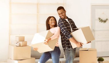 Ev taşıma konsepti. Evlerinde kutu taşıyan pozitif siyah bir çift var. Kopya alanı. Eşyaları olan Afro-Amerikalı kiracılar yeni bir eve taşınıyor. Panorama