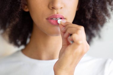 Hastalık, grip ve soğuk algınlığı, kendini iyi hissetmeme, yüksek ateş, baş ağrısı, migren ve ilaç. Ağrı kesici ya da vitamin alan ciddi bir Afro-Amerikalı kadın. Kapatın, boş yer açın.