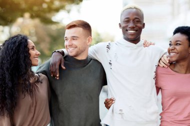 Uluslararası arkadaş grubu gülerek ve sokakta kucaklaşarak, tasasız, çok ırklı öğrencileri sıraya dizip dışarıda kucaklayarak, sohbet ederek, yakın çekim yaparak, panorama