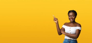 Gülümseyen siyahi bayan, sarı arkaplanda parmak işareti yapıyor, Afro-Amerikan Kadın Kadın Mesajınız ve Reklamınız İçin Bedava Yer Gösteriyor,