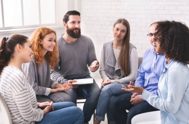 Rehabilitasyon grubu toplantısında hastalarla konuşan adam psikiyatrist, boş alan
