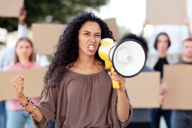 Çok ırklı genç protestocular ellerinde megafon ve boş pankartlarla sokağa saldırıyorlar. Dışarıyı protesto eden, insan haklarını savunan boş pankartlı uluslararası bir grup insan.