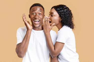 Afro-Amerikalı bir kadın erkek arkadaşının kulağına dedikodu fısıldıyor, sarı stüdyo geçmişi var. Siyahi kadın, haykıran ve el kol hareketi yapan hayrete düşmüş adamına aşk sözleri fısıldıyor.