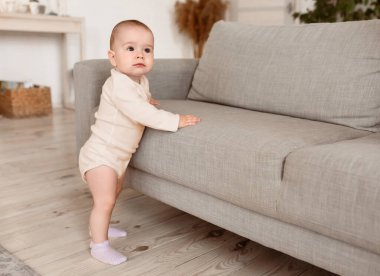 Evdeki oturma odasında mesajlaşmak için fotokopi çekilen koltuğun yanında duran şirin bebek bebek. Güzel küçük çocuk yalnız zaman geçiriyor. Çocukluk Konsepti