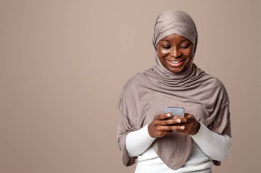 Mobil İletişim. Türbanlı Siyahi Müslüman Kadın Zeka Telefonu Kullanıyor, İnternete Bakıyor ya da Arkadaşlarla Mesajlaşıyor, Afrikalı İslamcı Kadın Başörtüsü İçinde Modern Teknolojileri Hoşlanıyor, Boşluğu Kopyala