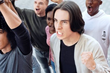 Kirlilik önleyici grev konsepti. Sokakta grev yapan, sloganlar atan, yumruklarını kaldıran, devletin gezegenini kurtarmasını isteyen, kirliliği azaltan uluslararası kızgın insanlardan oluşan bir grup.