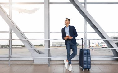 Havalimanı Terminali 'nde, yanında bavul taşıyan yakışıklı Arap Pasaportu ve Biletleri Bekleyen Genç Orta Doğulu Girişimci, Keyifli İş Gezisi, Kopya Alanı