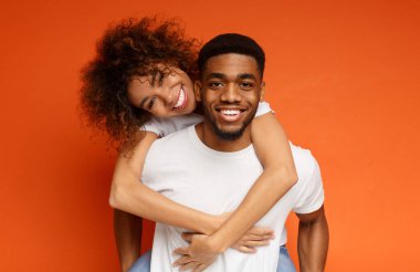 Turuncu zemin üzerine kucaklayan aşık tatlı Afrikalı-Amerikalı Çift