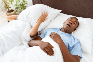 Sağlık sorunları, derin uyku ve apne, gürültü ve kötü gece. Genç Afro-Amerikan erkek horluyor, kadın acı çekiyor ve yüzünü yastıkla örtüyor. Böylece yatak odasında hiçbir erkek duymuyor.