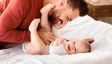 Sevimli bir baba, küçük kızına sarılıp evde yatarak vakit geçiriyor. Babacığının yeni yürümeye başlayan çocukla gülmesine bayılıyorum. Babalık, Babalık Sevgisi, Çocuk Bakımı ve Ebeveynlik neşesi