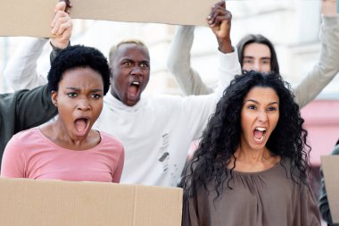 Uluslararası aktivist genç erkek ve kadın grupları ellerinde boş pankartlar ve sokakta sloganlar taşıyorlar. Irkçılık, kirlilik ve savaşa karşı grev yapan öfkeli göstericiler