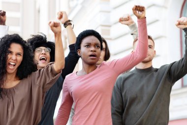 Çok ırklı bir grup genç gösterici dışarıda isyan çıkartıyor, yumruklarını kaldırıyor ve slogan atıyorlar. Sokaklarda grev yapan genç erkek ve kadınları motive etti