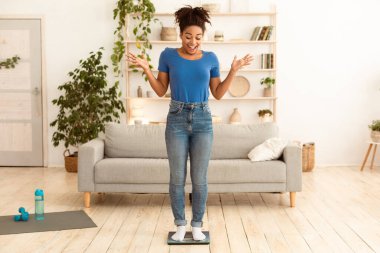 Kilo kaybı. Evde diyet yaptıktan sonra kilolarının üzerinde duran heyecanlı, zayıf siyah kız. Tam Uzunluk, Boş Alan