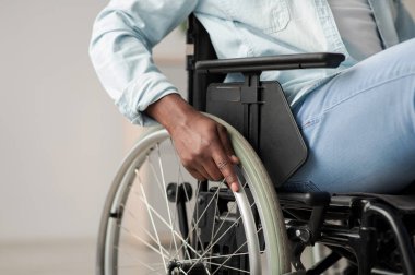 Hizmet hastaları ve engelliler hastanesi. Engellilere yardım için klinikteki tıbbi ekipmanlar. Hasta bakımı için tekerlekli sandalyedeki Afrikalı Amerikalı adam, eline odaklan.