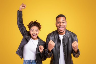 Neşeli Siyah Eşler Heyecanlı Yumruklar Hareketlendiriyor Stüdyoda Sarı Arkaplanda Duruyor. Zaferin Sevinci, Kazananlar ve Mutluluk, Pozitif Duygular