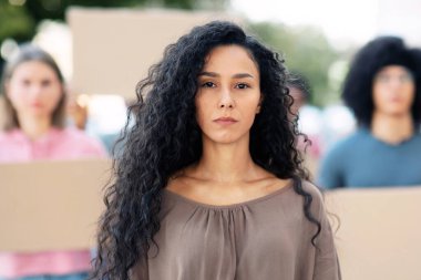 Irkçılığa karşı protestoya öncülük eden bir grup aktivistin başında duran kendinden emin, genç bir kadın. Coronavirus kısıtlamalarına karşı mücadele eden boş pankartlı uluslararası bir grup insan