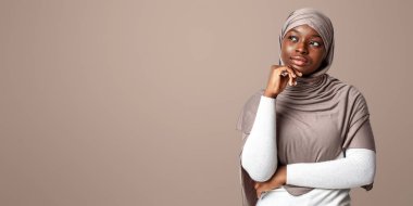 Bir düşüneyim. Türbanlı Afrikalı İslami Kadın Teklif ya da Anlaşma Hakkında Düşünüyor, Işık Stüdyolarının Arkasında Duruyor, Panorama