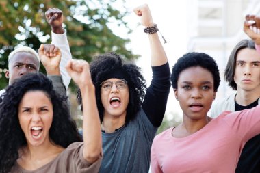 Uluslararası bir grup öğrenci gösteri sırasında slogan atıyor ve yumruk atıyor, eğitim reformlarına karşı mücadele ediyor, yakın çekim yapıyorlar. Öğrenciler miting, gösteri, grev konsepti