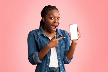 Mobil Uygulama. Heyecanlı Afrikalı Amerikalı Kadın, Pembe Stüdyo Arkaplanı Üzerine Boş Ekran Pozu Veren Telefon Gösteriyor. Model