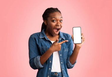 Mobil Uygulama. Heyecanlı Afrikalı Amerikalı Kadın, Pembe Stüdyo Arkaplanı Üzerine Boş Ekran Pozu Veren Telefon Gösteriyor. Model