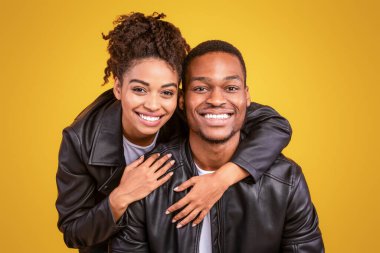 Sarı Stüdyo Arkaplanında Sarılan Siyah Çifti Sevmek, Kameraya Gülümsemek. Romantik İlişki Konsepti. Panorama