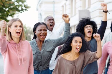 Duygusal çoklu etnik gruplara yakın grevciler milenyum erkek ve kadınları slogan atıyorlar ve sokak ya da hükümet binasının yanında yürürken yumruklarını kaldırıyorlar.