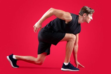 Formda genç sporcunun kırmızı stüdyo arkaplanından görünüşü. Bin yıllık güçlü bir spor giysi koşucusu. Yarışa ya da maratona hazır. Sağlıklı yaşam tarzı kavramı