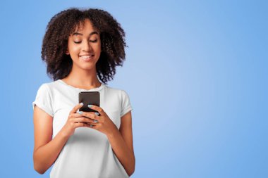 Romantik mesaj, sohbet, iyi bir ruh hali, sosyal ağlar ve mağazadan en iyi teklif. Mutlu Afro-Amerikan kadın telefonda yazıyor, menekşe arka planda izole edilmiş, boş alan, stüdyo çekimi.