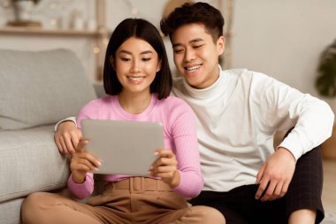 Japon Eşler Evde Otururken İnternette Dijital Tablet İzleyip Rahatlıyor. Mutlu Asyalı Genç Çiftler Hafta Sonu Filmi, Gadget Yaşam Tarzı Konsepti