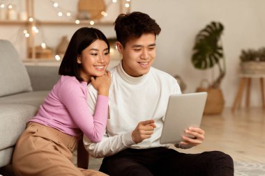 Mutlu Koreli Çiftler Hafta Sonu Evde Oturarak Tablet Bilgisayar İzliyor. Kız arkadaş ve erkek arkadaş geceyi birlikte geçiriyorlar. Özellikler ve Modern Yaşam Tarzı Konsepti