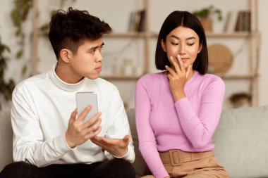 İlişkide sadakatsizlik var. Kıskanç Çinli koca, aldatan karısını cep telefonuyla evde koltukta otururken izah isterken gösteriyor. Erkek Arkadaşı Sadakatsiz Kız Arkadaştan Şüpheleniyor