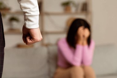Aile içi şiddet mağduru. Kızgın Asyalı koca yumruğunu sıkarak korkmuş eş içeride ağlıyordu. Evde fiziksel şiddet, tacizciyle ilişki, sosyal aile sorunları. Seçici Odaklanma