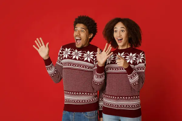 Şok edici ve beklenmedik bir buluşma. Şaşırtıcı binlerce yıllık Afro-Amerikan erkek ve dişisi, kırmızı arka planda izole edilmiş, sürpriz, el kol hareketi ve boş alana bakma gibi olumlu duyguları ifade ederler.