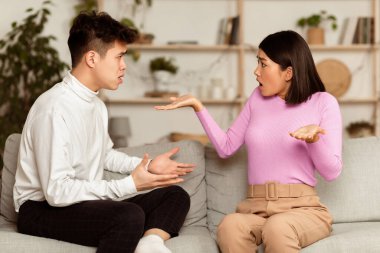 Asyalı eşler evdeki koltukta otururken kavga ediyorlar. Romantik İlişki Sorunları, Ayrılık ve Boşanma Kavramı. Çinli Aile Çifti Tartışıyor.