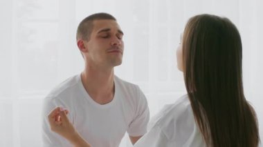 Genç bir çift, doğal ışıkla dolu parlak bir yatak odasında rahatça oturur. Birbirlerinin gözlerinin içine bakıp, sevgi ve bağ kurdukları hassas bir anı paylaşırlar..