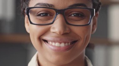 Odaklanmış bir Afro-Amerikalı kadın online bir ders veriyor, bilgisayarından öğrencilerle iletişim kuruyor. Uzak bir öğrenim ortamında modern eğitimi temsil ediyor..