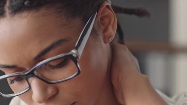 Gözlüklü siyahi bir kadın online öğretmenlik yapıyor, ev ortamından uzak öğrencilerle bilgi paylaşıyor. Eğitime odaklanması ve kendini adaması çok açık..