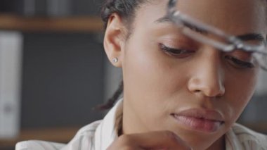 Gözlüklü kendini adamış bir Afrikalı Amerikalı kadın uzaktan eğitim görüyor. Öğrencilerle etkileşime girerken dikkatle odaklanır ve destekleyici bir öğrenme ortamı yaratır..