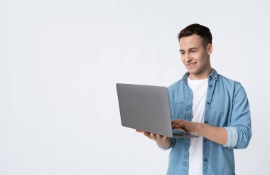 Bilgisayarla çalışan gülümseyen adam beyaz arka planda izole edilmiş.