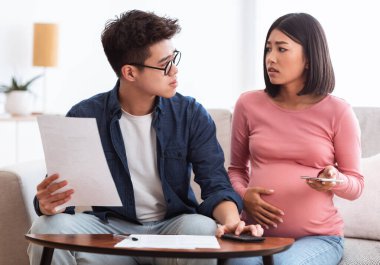 İflas. Masraflarını ve faturalarını hesaplayan ve evdeki koltukta oturan borçlarını ödeyemeyen Asyalı bir çift ekonomik kriz yaşıyor. Mali sorunlar, Coronacrisis kavramı