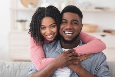 Afrika kökenli Amerikalı çiftin evde sarılıp kameraya baktıkları ve karantinayı birlikte geçirdikleri portre.