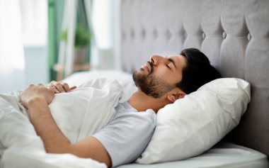 Derin erkek uykusu. Genç Arap adam evdeki rahat yatağında huzur içinde uyuyor, gözleri kapalı yatıyor. Dinlenme, dinlenme ve şekerleme zamanı.