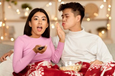 Heyecanlı Asyalı Eş, Kocanı Öpmeyi Reddeden TV izliyor, Favori Noel Filmlerini ve Evde Patlamış Mısırla Oturan Kış Dizilerini izliyor. En iyi Yeni Yıl Tatil Filmi. Seçici Odaklanma