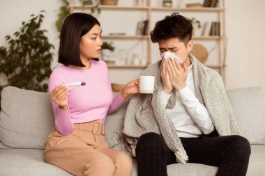 Yardımcı Asyalı Eş Hasta Kocasına Hasta Tedavi Ediyor Evdeki Kanepede Otururken İlaç Veriyor. Koreli Kız Arkadaş, Hasta Erkek Arkadaşla İlgilenir. Mevsimlik Grip, Soğuk, Hastalık Konsepti