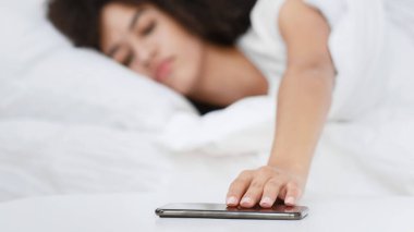 Depresyon, işe dönmek, erken kalkmak ve paniğe kapılmak. Çaresiz genç Afrikalı Amerikalı kadın yatağa uzanıyor ve telefona uzanıyor, rahat yatak odasının içinde, boş alanda, aletlere odaklanıyor.