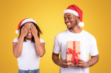 Siyah Koca, Noel Hediyesi Kucağında Yılbaşı Tatillerinde Karısını Kutlarken, Sarı Stüdyo Arkaplanında Bekleyen Gözleri Kapatıyordu. Yeni Yıl Hediyeleri ve Kutlamalar